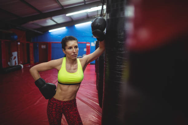 istock Female boxer leaning on punching bag 649360040