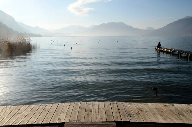 istock Man sitting on pontoon lake annecy 649363200