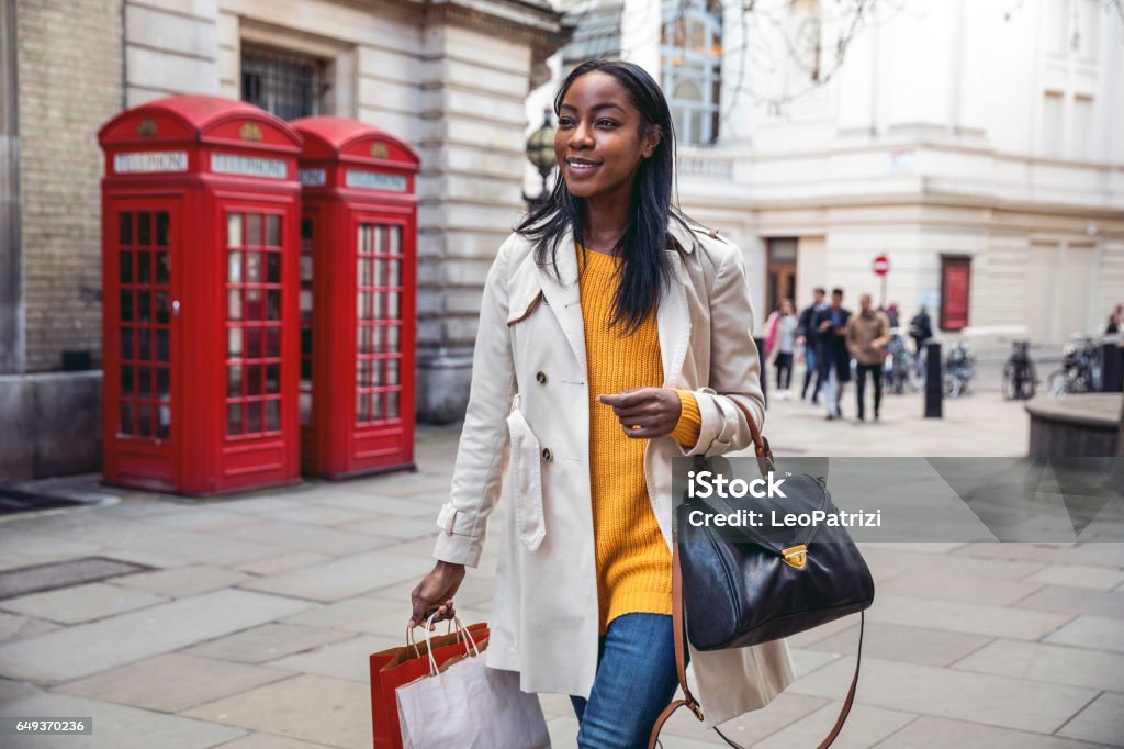 Woman walking in Central London for shopping Outdoor walks, one young black woman walking in Central London for shopping Shopping Stock Photo