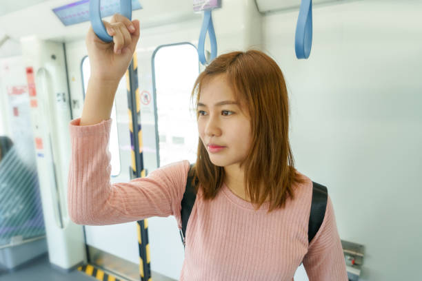 Woman traveler holding the train rails while taking sky train. stock photo