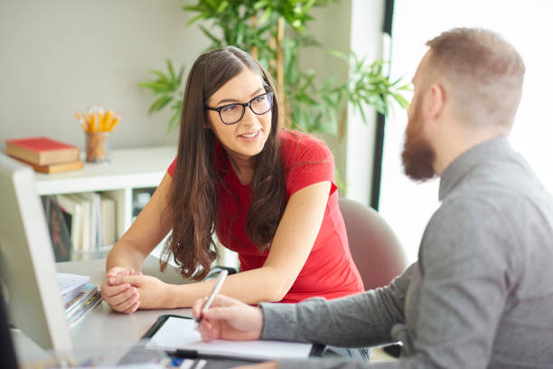 first job graduate intern a female university student sits at a desk and has a one to one with her tutor or mentor . guidance support stock pictures, royalty-free photos & images