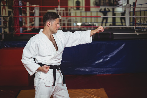 Karate player practicing karate stance in fitness studio