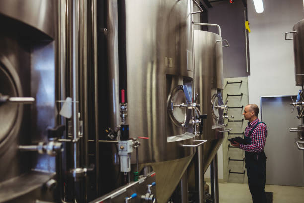 istock Owner examining machinery at brewery 649396096