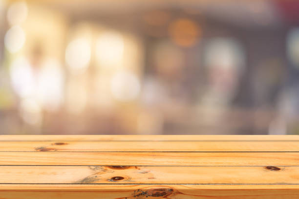 istock Wooden board empty table top on of blurred background. Perspective brown wood table over blur in coffee shop background - can be used mock up for montage products display or design key visual layout. 649396270