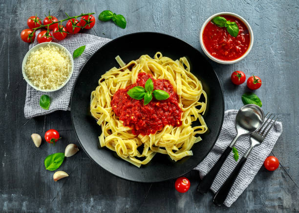 hausgemachte heiße pasta mit marinara sauce, basilikum, knoblauch, tomaten, parmesan-käse auf platte. - tomato soup red basil table stock-fotos und bilder