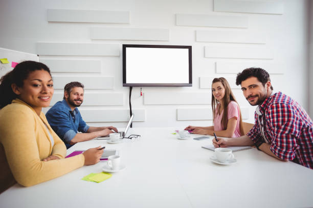 istock Portrait of confident partners during board meeting at creative office 649403098