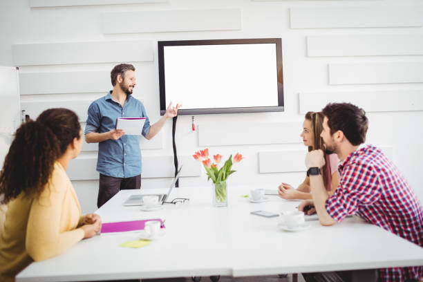 istock Colleagues listening to executive in meeting at creative office 649403266