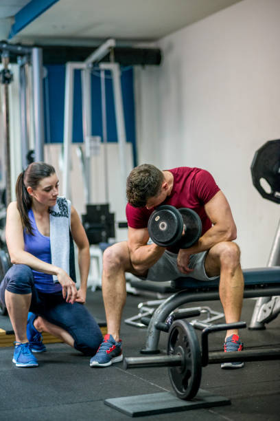 istock Personal trainer help sportsman workout with dumbbells at the gym. 649417764