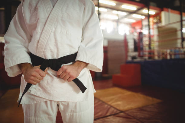 section médiane du joueur de karaté attacher sa ceinture - karate punching bag caucasian leisure activity photos et images de collection