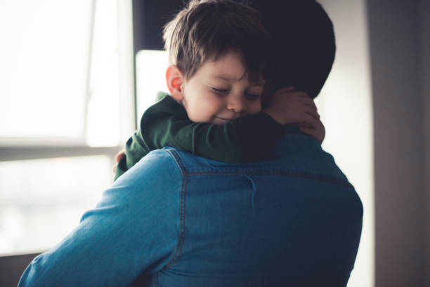 Feeling happy in dad's arms Dad and cute little son sharing an emotional hug. one parent stock pictures, royalty-free photos & images