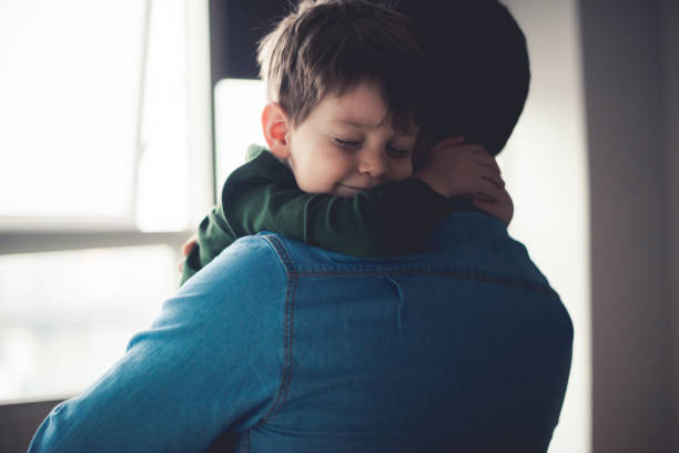 Feeling happy in dad's arms Dad and cute little son sharing an emotional hug. father stock pictures, royalty-free photos & images