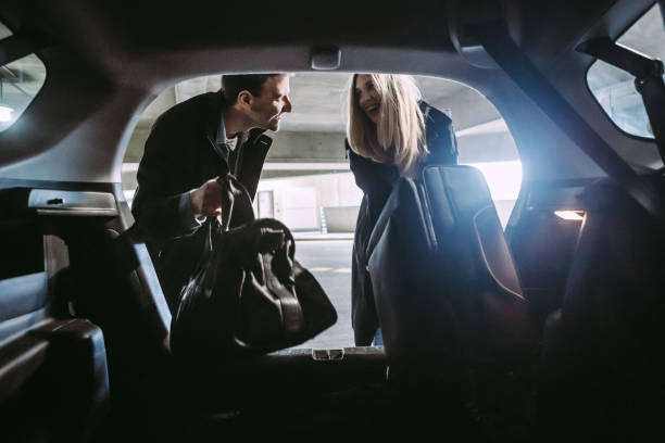pareja en el garaje del aparcamiento del aeropuerto - car for sale fotografías e imágenes de stock