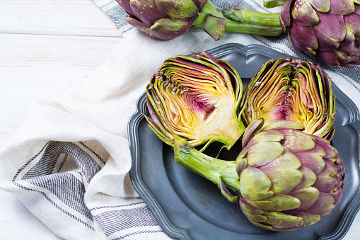 Fresh big Romanesco artichokes green-purple flower heads ready to cook seasonal food