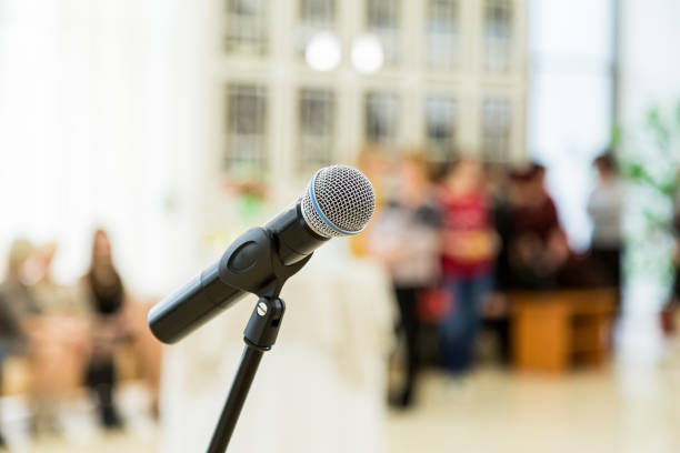 istock Wireless microphone on the stand at a reception in the hall. People in the background. Blurred background. Bokeh 649449128