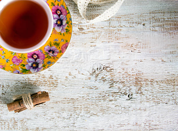 Cup of tea whith cinnamon on white wood  background