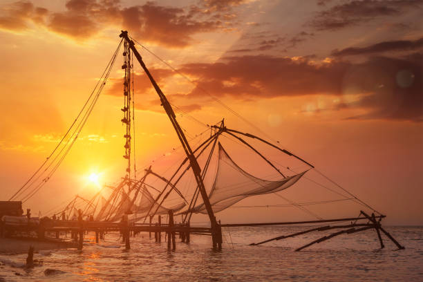 Kochi chinese fishnets on sunset. Fort Kochin, Kochi, Kerala, India. With lens flare and light leak