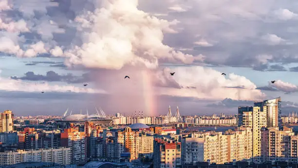 High quality and resolution photo with urban view on New Stadium in Saint-Petersburg Russia constructed for events like FIFA World Cup 2018, UEFA Euro 2020, FIFA Confederations Cup 2017 and other events. Rainy weather clouds and rainbow makes beautiful look on sunset.