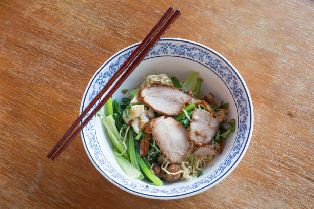 istock Thai noodle pok pok with chopsticks on wooden table 649464702