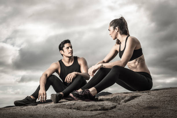 A Hispanic couple resting and holding a bottle of water.  Up high with a view of a Southern California nieghborhood.