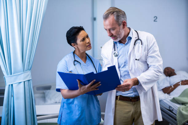 istock Doctor and nurse having discussion on file in ward 649496462