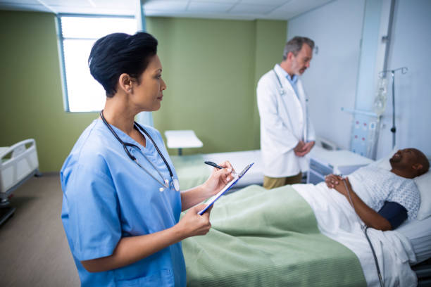 istock Female nurse writing on clipboard during visit in ward 649497370