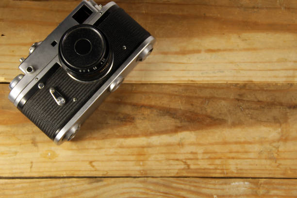 istock Retro photo camera on wooden background 649502994