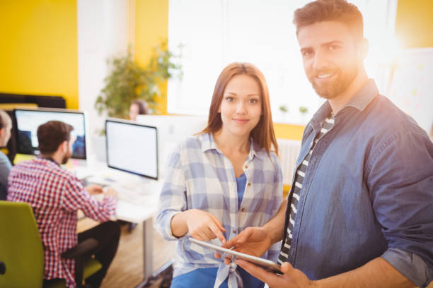 istock Portrait of confident business people using tablet computer at creative office 649510690