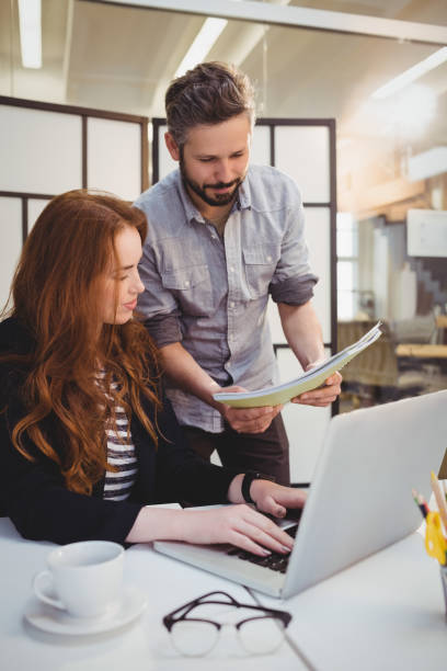 istock Businessman showing document to female colleague 649512078