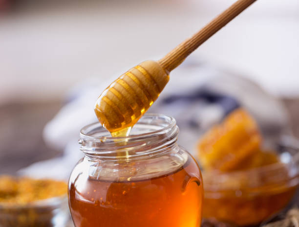 istock dripping sweet honey from wooden dipper 649514568