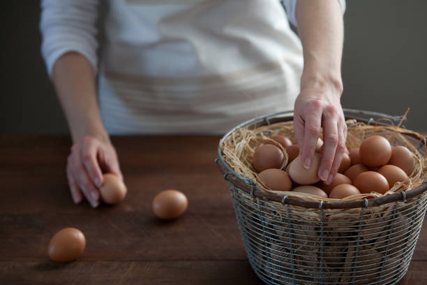 istock Woman Taking Fresh Chicken Eggs From Basket 649514584