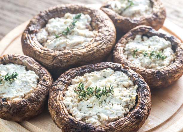 Baked mushrooms stuffed with feta Baked mushrooms stuffed with feta crimini mushroom stock pictures, royalty-free photos & images