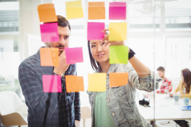 istock Creative business people looking at multi colored sticky notes on glass 649524742