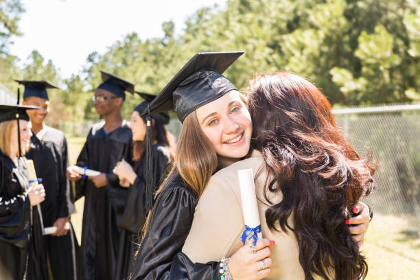 istock College, high school student hugs mom after graduation ceremony. 649525064