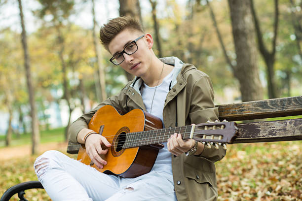 istock Man playing a guitar in nature 649528164