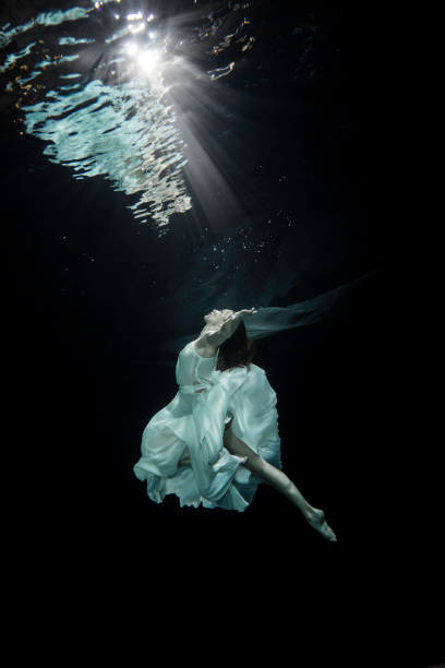 istock Young female ballet dancer dancing underwater 649549660