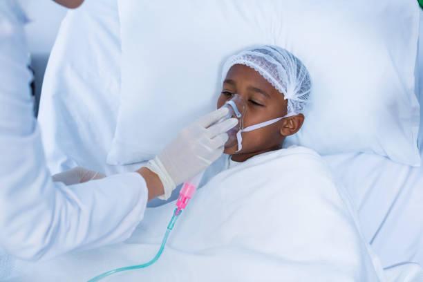 Doctor placing an oxygen mask on patient in hospital