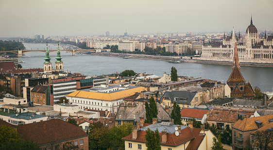 A picture of some Budapest landmarks, such as the Hungarian Parliament Building, the Szilagyi Dezso Square Reformed Church and the Saint Anne Parish Church siding the Danube river.