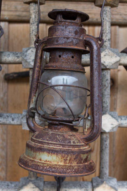 istock Old rusty kerosene lamp hanging on a metal grid in village 649552214