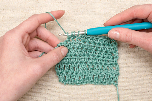 Crochet double stitching with teal yarn