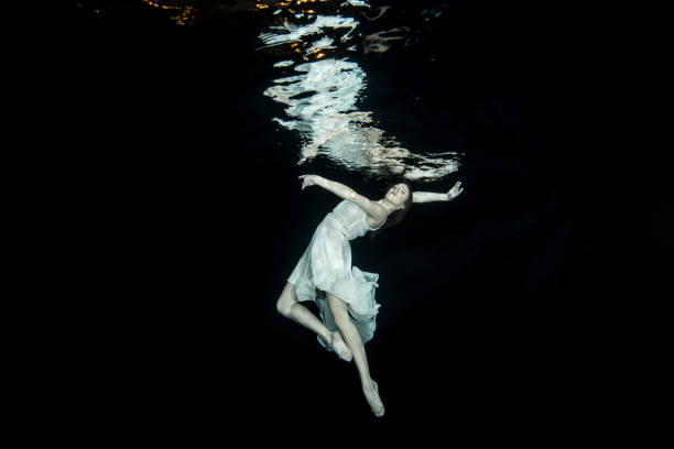 istock Young female ballet dancer dancing underwater 649559452
