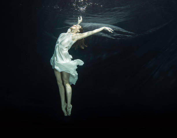 istock Young female ballet dancer dancing underwater 649559466