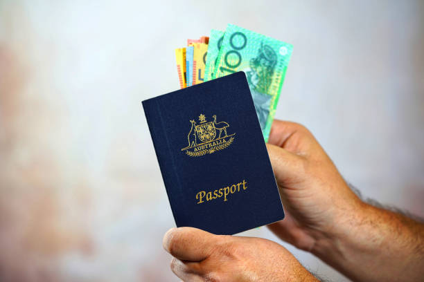 istock Man putting Australian money into passport 649562890