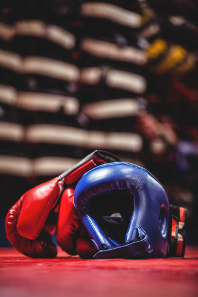 Pair of boxing gloves and headgear in boxing ring