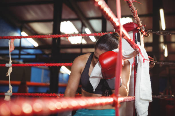 istock Tired female boxer sitting in the ring 649569152