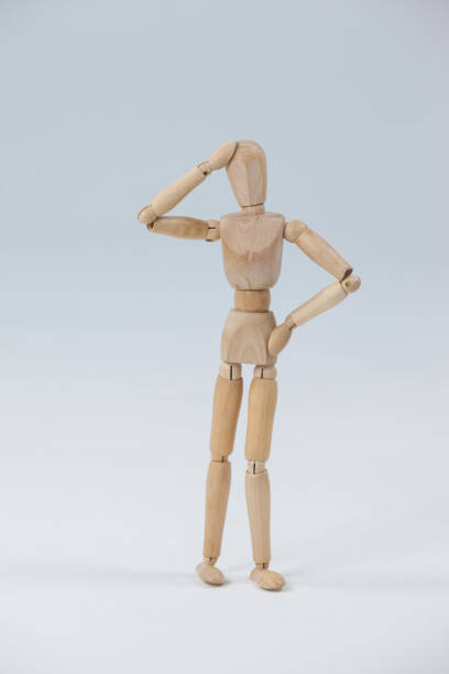 istock Confused wooden figurine standing with hand on head 649581184