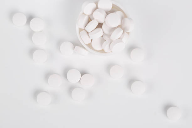 istock Top view of round white pills on the white background 649583562