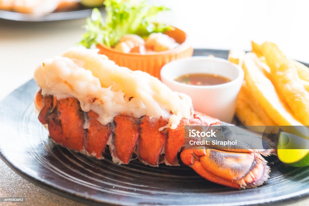 Lobster steak Selective focus point on Lobster steak in black plateSelective focus point on Lobster steak in black plate Lobster - Seafood Stock Photo