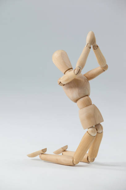 istock Wooden figurine kneeling with both hands joined 649584198
