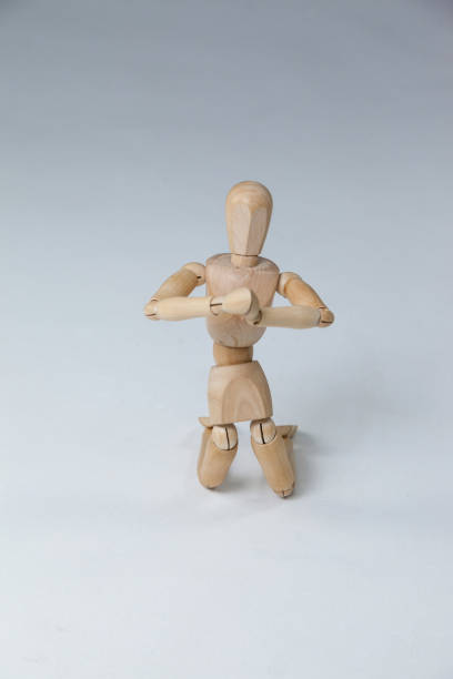 istock Wooden figurine kneeling with both hands joined 649584268
