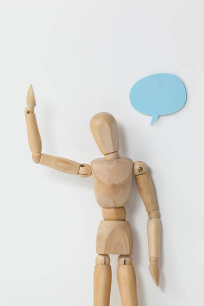 istock Thoughtful wooden figurine standing with hand raised 649584570